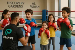 Kids boxing lessons in Discovery Gardens near Al Furjan with boxing coach wearing imran pt logo